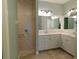 Bathroom featuring double sinks, a tiled walk-in shower, and modern fixtures at 24289 Toth Ln, Punta Gorda, FL 33955