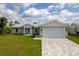 Newly built home with light gray exterior, white garage door, and landscaped lawn at 8126 Chesebro Ave, North Port, FL 34287