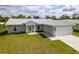 Single-story home with gray siding, white trim, and a paved driveway at 8126 Chesebro Ave, North Port, FL 34287