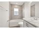 Well-lit bathroom featuring a shower-tub combo with tiled walls at 2614 58Th E Cir, Palmetto, FL 34221