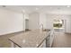 Open-concept kitchen featuring a large island with granite countertop and stainless steel sink at 2614 58Th E Cir, Palmetto, FL 34221