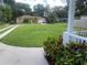 Spacious front yard with a large grassy area and mature trees at 6704 N 13Th St, Tampa, FL 33604