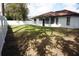 Backyard featuring a mix of grass and shaded areas with a white fence along the property line at 1413 Sandalwood Dr, Plant City, FL 33563