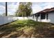 Backyard featuring a mix of grass and shaded areas with a tall white privacy fence at 1413 Sandalwood Dr, Plant City, FL 33563