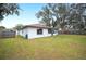 Spacious backyard featuring a well-maintained lawn, mature trees, and partial fencing at 1413 Sandalwood Dr, Plant City, FL 33563