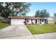 Newly renovated home with a well-manicured lawn and a large driveway at 1413 Sandalwood Dr, Plant City, FL 33563
