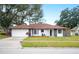Charming single-story home with a red tile roof, white exterior, and stone accents at 1413 Sandalwood Dr, Plant City, FL 33563