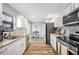 Modern kitchen with white cabinets, granite countertops, and stainless steel appliances at 1413 Sandalwood Dr, Plant City, FL 33563