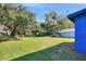Large backyard with a blue house and mature trees at 1106 Powell St, Plant City, FL 33563