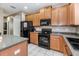 Modern kitchen with wood cabinets, black appliances and breakfast bar at 269 Fairmont Dr, Spring Hill, FL 34609