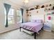 Light and airy bedroom with a purple bedspread and built-in shelves at 11701 Brighton Knoll Loop, Riverview, FL 33579