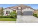 Two-story house with gray siding, stone accents, and a three-car garage at 11701 Brighton Knoll Loop, Riverview, FL 33579