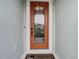 Orange front door with glass accents and a welcome mat at 11701 Brighton Knoll Loop, Riverview, FL 33579