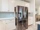 Stainless steel refrigerator in a modern kitchen setting with white cabinets at 11701 Brighton Knoll Loop, Riverview, FL 33579