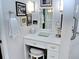 Vanity with white cabinets, a quartz countertop, and framed Gathering photos at 130 Bay Plz, Treasure Island, FL 33706