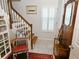 Inviting entryway with hardwood stairs, shuttered window, and decorative furnishings at 130 Bay Plz, Treasure Island, FL 33706