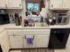 Kitchen features double sink, dishwasher, and microwave at 1415 Doolittle Ln # 107, Dunedin, FL 34698