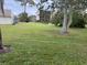 Landscaped lawn with mature trees and building view at 1415 Doolittle Ln # 107, Dunedin, FL 34698