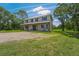 Two-story home with front porch, gravel driveway, and mature landscaping at 3011 39Th E St, Bradenton, FL 34208