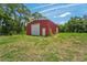 Spacious red metal workshop with a large roll-up door at 3011 39Th E St, Bradenton, FL 34208