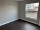 Bedroom with a window, dark laminate floors, and neutral walls at 4710 Bloom Dr, Plant City, FL 33566