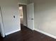 Bedroom with dark laminate floors and an interior door at 4710 Bloom Dr, Plant City, FL 33566