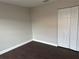 Bright bedroom featuring dark laminate wood floors and a double door closet at 4710 Bloom Dr, Plant City, FL 33566