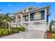 Modern two-story home with a paver driveway and manicured landscaping at 7899 Causeway N Blvd, St Petersburg, FL 33707