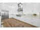 White kitchen with stainless steel appliances and hardwood floors at 7899 Causeway N Blvd, St Petersburg, FL 33707