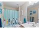 Bright bathroom featuring a surfboard-themed shower curtain, decor and a large mirror above the sink at 19245 Wood Sage Dr, Tampa, FL 33647