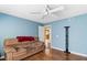 Cozy bedroom with a ceiling fan, couch and warm blue paint creating a relaxing atmosphere at 19245 Wood Sage Dr, Tampa, FL 33647