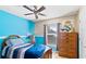 Bright bedroom featuring unique two-tone walls, ceiling fan, and a spacious dresser for ample storage at 19245 Wood Sage Dr, Tampa, FL 33647