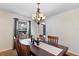 Bright dining room featuring hardwood floors, a rustic table, and a modern chandelier at 19245 Wood Sage Dr, Tampa, FL 33647