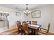 Dining room featuring a chandelier, hardwood floors, and a rustic table with chairs at 19245 Wood Sage Dr, Tampa, FL 33647