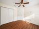 Bedroom with wood floors, ceiling fan, and double doors at 4512 Preston Woods Dr, Valrico, FL 33596