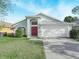 One-story house with red door, white garage, and manicured lawn at 4512 Preston Woods Dr, Valrico, FL 33596