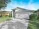 House exterior with a white garage door and red door at 4512 Preston Woods Dr, Valrico, FL 33596