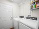 Bright laundry room with washer, dryer, and shelving at 4512 Preston Woods Dr, Valrico, FL 33596