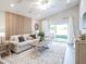 Living room featuring a neutral couch, wooden coffee table and wall decor at 6015 Mangrove Creek Rd, Wimauma, FL 33598