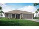 One-story home with gray exterior, two-car garage, and lush lawn at 6042 Mangrove Creek Rd, Wimauma, FL 33598