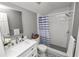 Modern bathroom with white vanity, striped shower curtain, and patterned floor at 9713 Royce Dr, Tampa, FL 33626