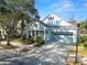Light blue house with white columns, two-car garage, and manicured landscaping at 9713 Royce Dr, Tampa, FL 33626