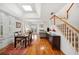 Bright open-concept living room featuring hardwood floors, a fireplace, staircase, and plantation shutters at 2311 W Morrison Ave # 13, Tampa, FL 33629