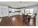 Open kitchen and dining area with white cabinets, appliances, and wood-look floors at 3415 N 53Rd St, Tampa, FL 33619