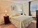 Main bedroom with a queen-size bed and wicker nightstands at 936 Virginia St # 208, Dunedin, FL 34698