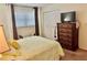 Well-lit bedroom featuring a queen bed, dresser, and large closet at 936 Virginia St # 208, Dunedin, FL 34698