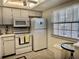 White kitchen with microwave, stove, and refrigerator at 936 Virginia St # 208, Dunedin, FL 34698