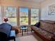 Relaxing sunroom with a futon and picturesque lake views at 936 Virginia St # 208, Dunedin, FL 34698