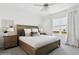 Sunlit bedroom featuring a queen-sized bed, stylish wooden furnishings, and a calming atmosphere at 11658 Bluestone Ct, Parrish, FL 34219