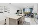 Bright kitchen island with a sink, pendant lighting, and an open view to the living area at 11658 Bluestone Ct, Parrish, FL 34219